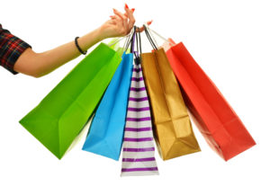 Female hand holding paper shopping bags isolated on white